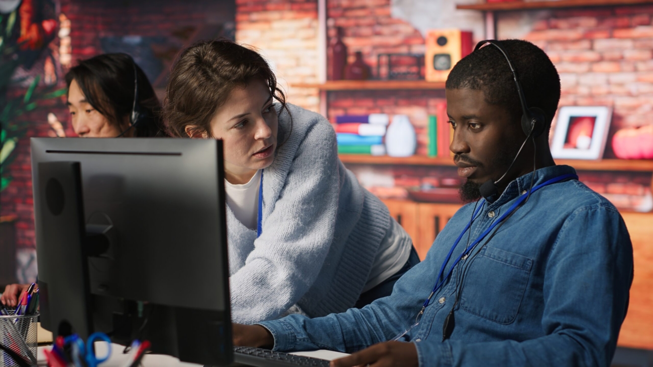 Call center manager teaching intern how to track clients shipment parcels. Customer center team leader doing induction to trainee, locating clients packages and providing status updates, camera A